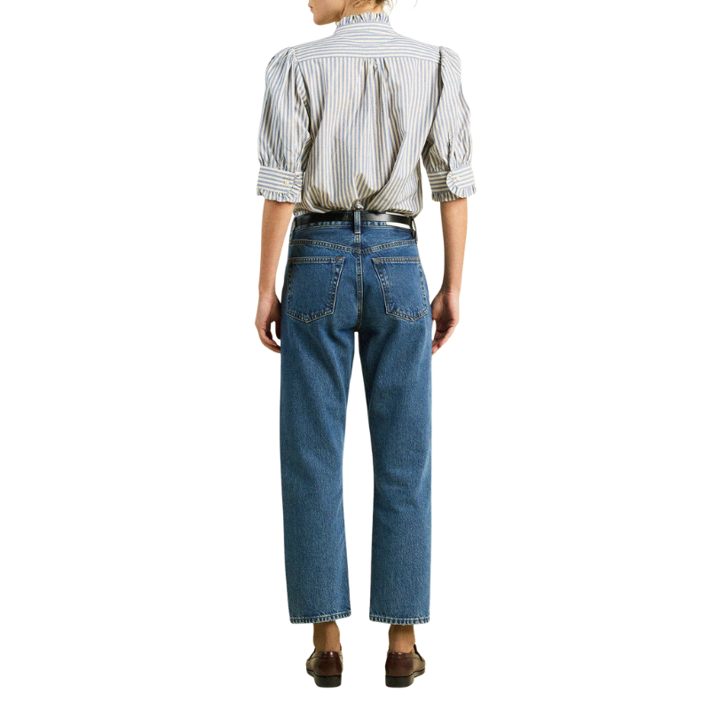 Person wearing a striped shirt and blue jeans on a white background