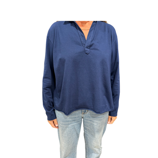 Person wearing a blue long-sleeve shirt and light blue jeans on a white background