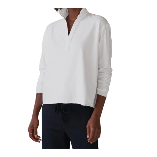 Person wearing a white long-sleeve shirt and dark pants on a white background