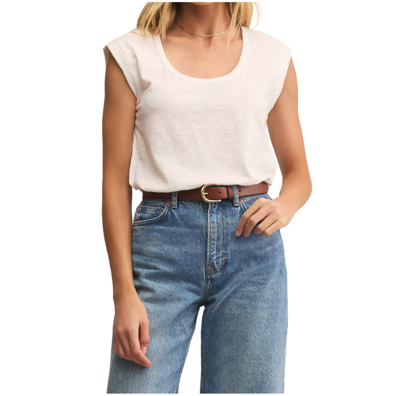 Person wearing a white sleeveless top and blue jeans on a white background