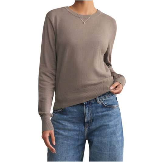 Person wearing a brown sweater and blue jeans on a white background