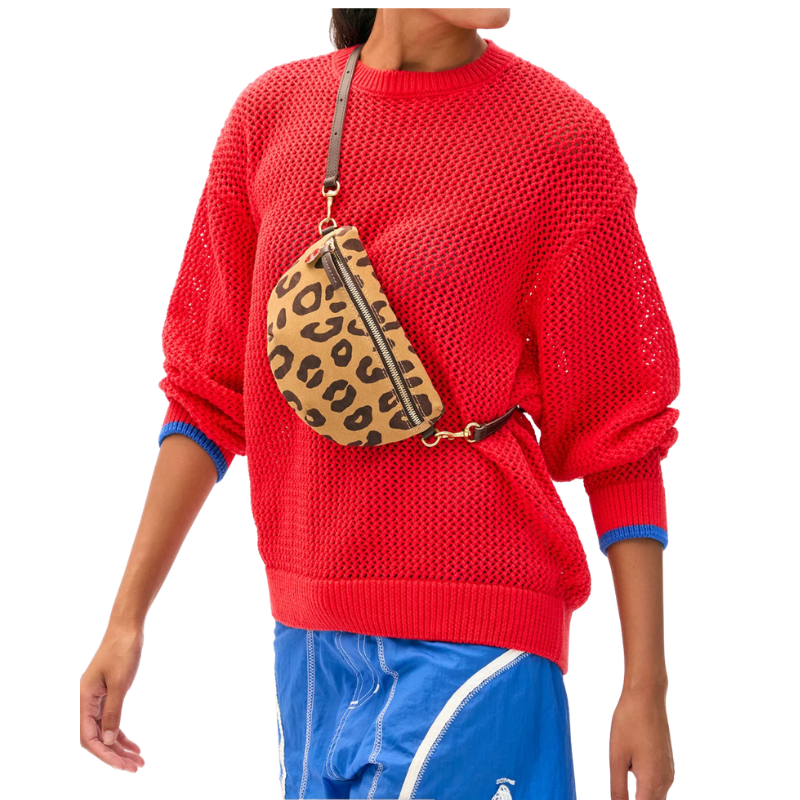 Person wearing a red sweater with a leopard print bag over their shoulder on a white background
