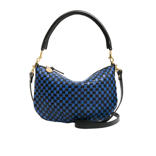 Blue checkered handbag with black handle and strap on a white background