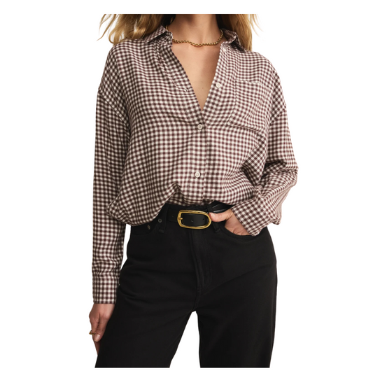 Person wearing a checkered shirt and black pants on a white background