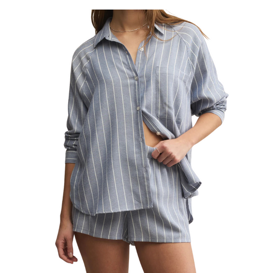 Woman wearing a blue and white striped shirt and shorts on a white background