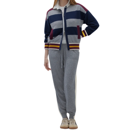 Person wearing a striped sweater and gray pants on a white background