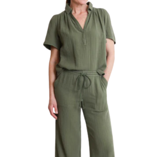 Green jumpsuit worn by a person on a white background