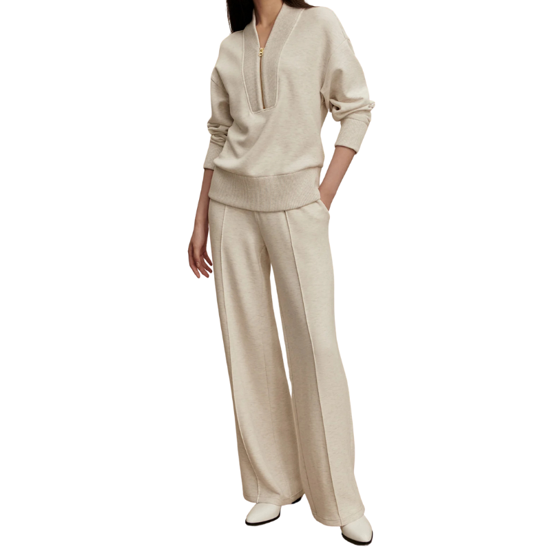 Woman wearing a beige sweater and pants set on a white background