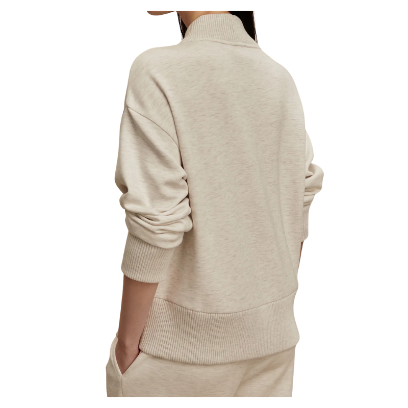 Beige sweater worn by a person on a white background