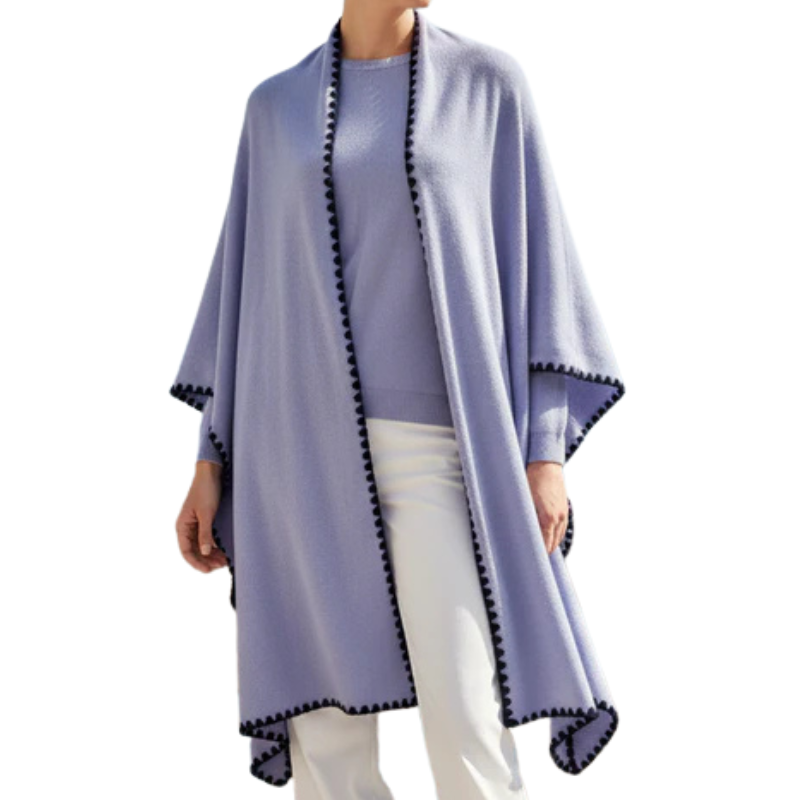 Person wearing a light purple poncho with black trim on a white background