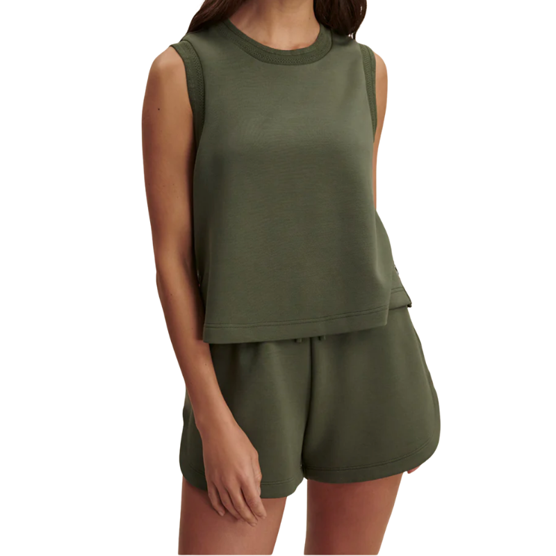 Person wearing a green sleeveless top and shorts set on a white background