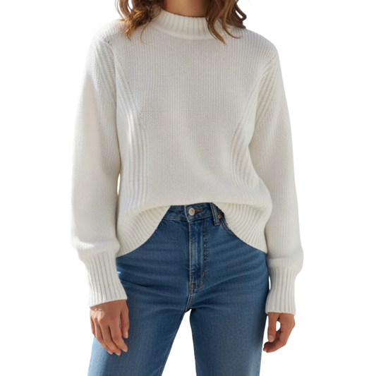 Person wearing a white ribbed sweater and blue jeans on a white background