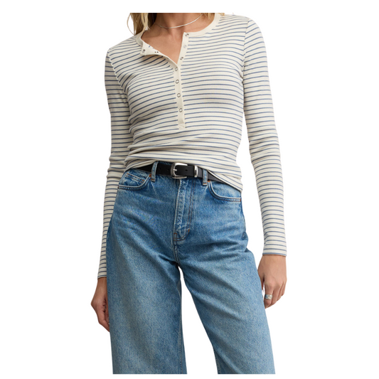 Person wearing a striped long-sleeve shirt and blue jeans on a white background
