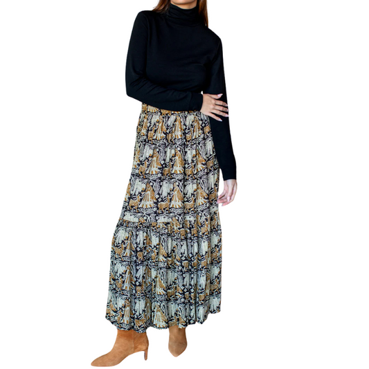 Person wearing a black turtleneck and patterned skirt on a white background