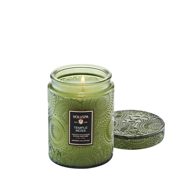 Green textured candle with lid on a white background