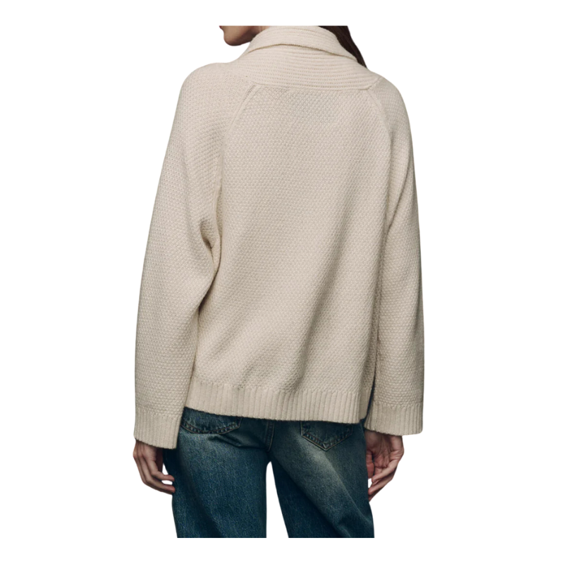 Beige sweater worn by a person on a white background