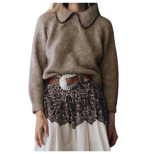 Brown sweater with lace trim worn by a person on a white background