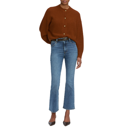 Person wearing a brown cardigan and blue jeans on a white background