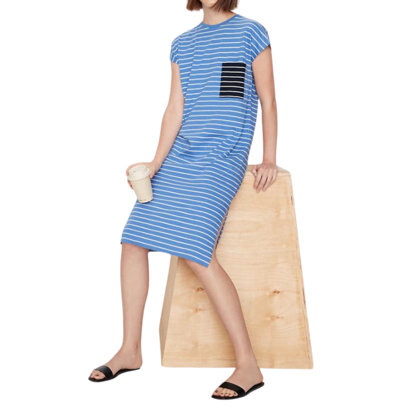 Woman wearing a blue striped dress with a black square design, standing against a white background.