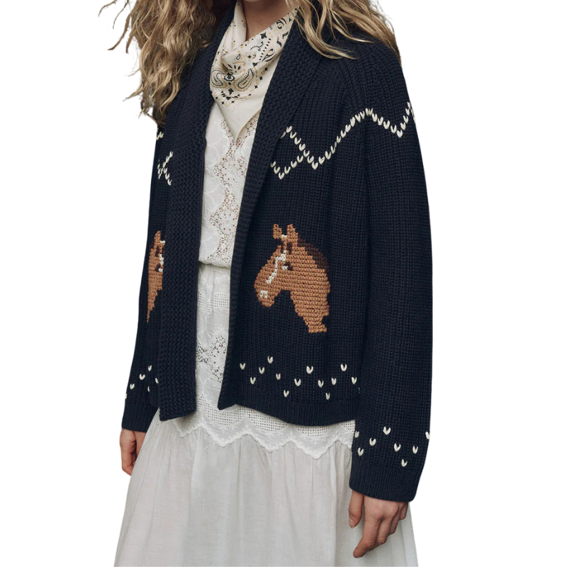 Navy blue cardigan with horse designs worn by a person on a white background