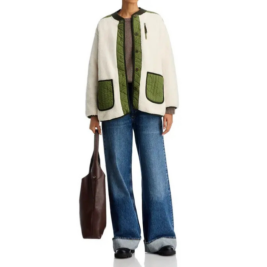 Person wearing a white and green jacket with blue jeans on a white background
