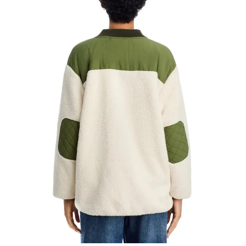 Person wearing a green and beige quilted jacket on a white background