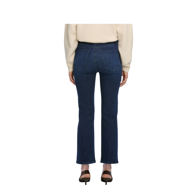 Person wearing blue jeans and a beige sweater on a white background