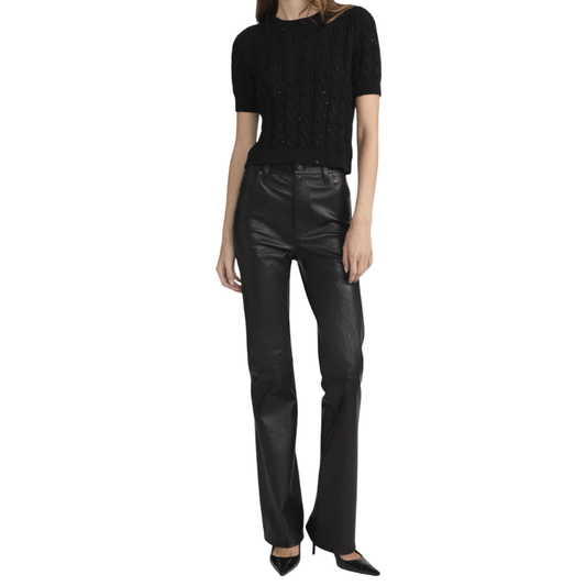 Person wearing a black top and leather pants on a white background