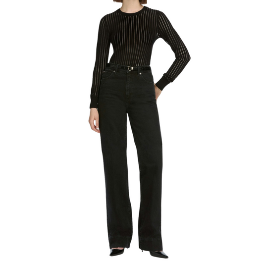 Person wearing a black ribbed sweater and black jeans on a white background