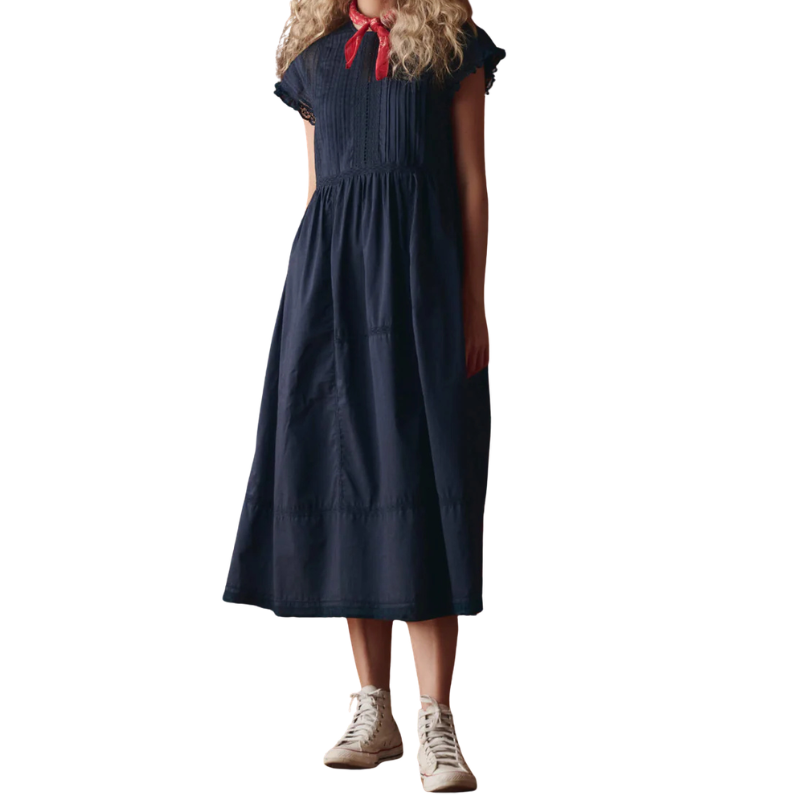 Woman wearing a navy dress with a red ribbon on a white background