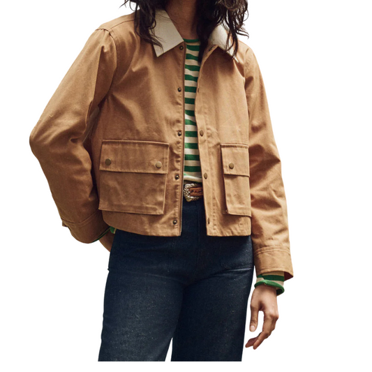 Person wearing a tan jacket over a striped shirt with a white background