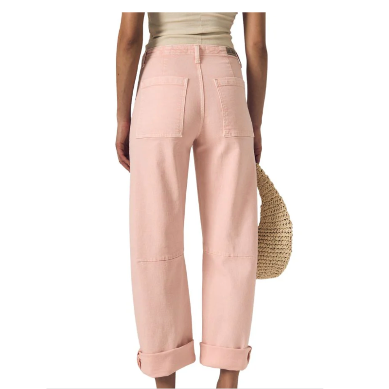 Person wearing light pink pants with a white background