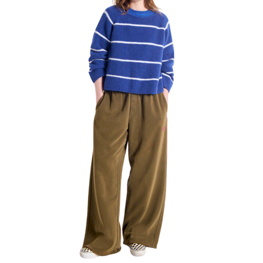 Person wearing a blue and white striped sweater and brown wide-leg pants on a white background