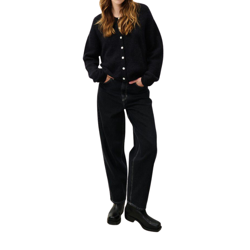 Person wearing a black cardigan, black pants, and black shoes on a white background