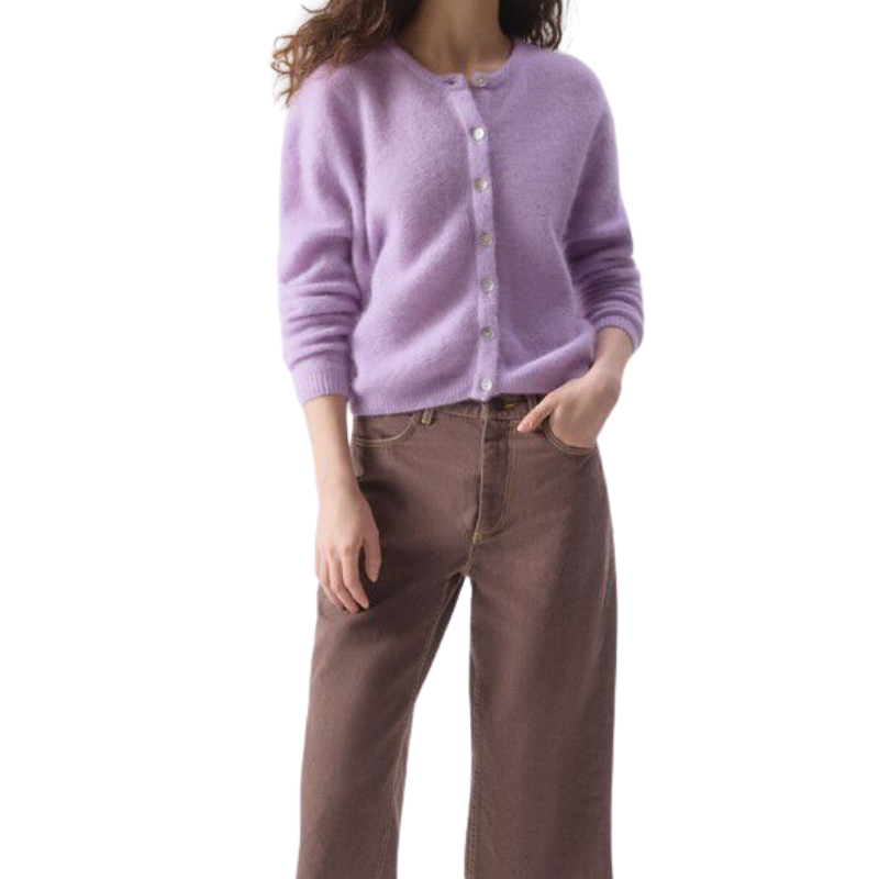 Person wearing a light purple cardigan and brown pants on a white background