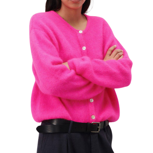 Person wearing a bright pink cardigan with button details on a white background