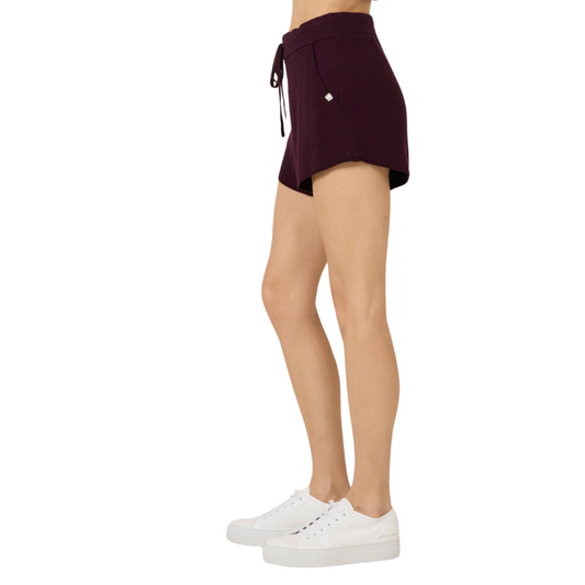 Person wearing a dark purple skirt with a white background