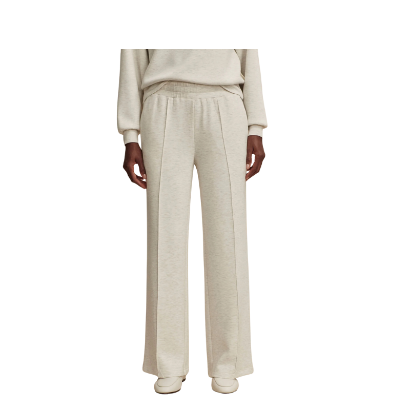 Person wearing a beige outfit with wide-leg pants on a white background