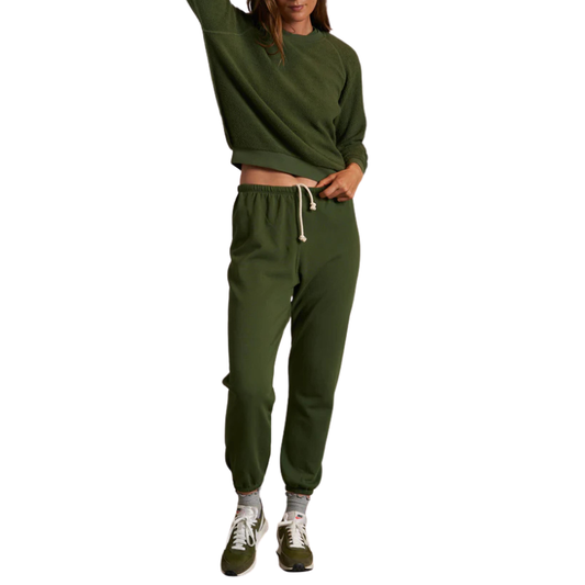 Person wearing a green sweatshirt and pants on a white background