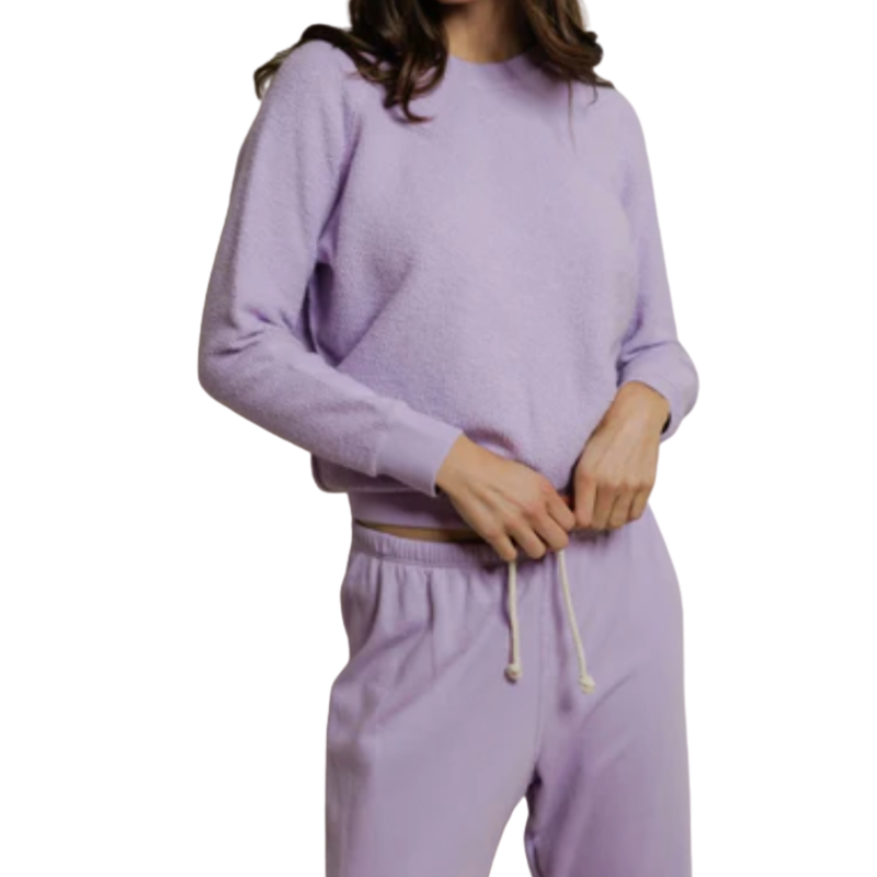 Person wearing a lavender tracksuit on a white background