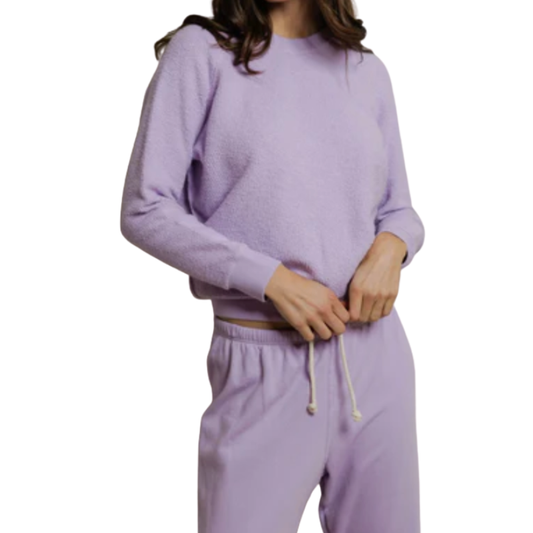 Person wearing a lavender tracksuit on a white background