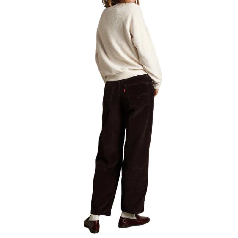 Person wearing a white sweater and black pants on a white background